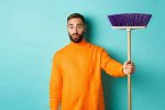 pngtree-man-standing-over-light-blue-background-looking-confused-while-receiving-a-broom-to-do...jpg